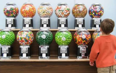 How to Start a Candy Machine Business Without Losing Your Shirt on Bad Locations Small business owner restocking a candy vending machine business machine in an office break room